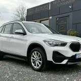 Białe BMW iX1 przed salonem samochodowym. Sprawdź atrakcyjną bmw ix1 cena!