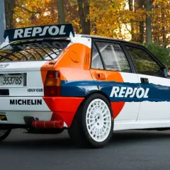 Ikoniczna Lancia Delta Integrale w barwach Repsol, z białymi felgami i naklejkami Michelin, gotowa do rajdu.