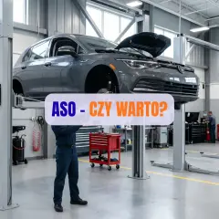 Mechanik pracuje pod samochodem na podnośniku w ASO. Czy warto?