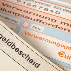 Zbliżenie na niemieckie mandaty, w tym "Bußgeldbescheid" i "Verwarnungsgeld" z symbolem euro.