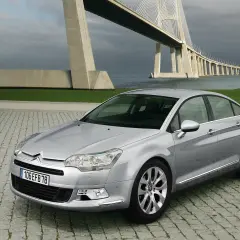 Srebrny Citroen C5 2.0 HDI na tle imponującego mostu wiszącego.