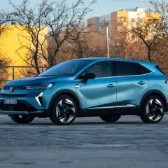 Niebieski Renault Symbioz na tle budynków i drzew. Wiele osób szuka o nim pozytywnych **renault symbioz opinie**.