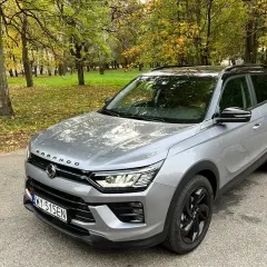 Srebrny SsangYong Korando na tle jesiennego parku. Wiele pozytywnych ssangyong korando - opinie użytkowników potwierdza jego wszechstronność.
