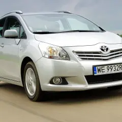 Srebrna Toyota Verso 1.8 benzyna w ruchu, z zielonym polem w tle.