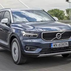 Ciemnoszary Volvo XC40 jedzie po moście. Sprawdź aktualną volvo xc40 cena i dostępne wersje.