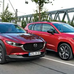 Dwa czerwone SUV-y jadące obok siebie. Po lewej Mazda CX-30, po prawej Seat Ateca. Porównanie mazda cx 30 wymiary.