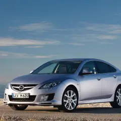 Srebrna Mazda 6 2.0 benzyna na tle błękitnego nieba i gór.