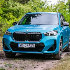 Niebieskie BMW X1 na leśnej drodze. Sprawdź jego kompaktowe bmw x1 wymiary, idealne do miasta i poza nim.