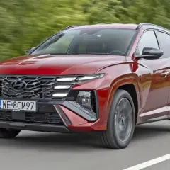 Czerwony Hyundai Tucson w ruchu drogowym. Zwróć uwagę na jego nowoczesny design i imponujące **hyundai tucson wymiary**, które zapewniają komfort i przestronność.