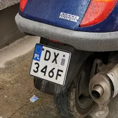 Skuter Honda Pantheon z tablicą rejestracyjną DX 346F, gotowy do jazdy po deszczu.