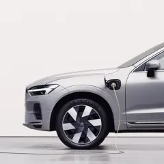 Srebrny samochód typu PHEV jest ładowany. To połączenie silnika spalinowego i elektrycznego, co oznacza, że możesz jeździć na prądzie lub paliwie.