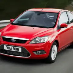 Czerwony Ford Focus MK2 1.6 benzyna w ruchu na zakręcie drogi.