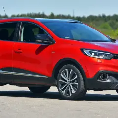 Czerwony Renault Kadjar na drodze. Wiele pozytywnych **renault kadjar opinie** potwierdza jego atrakcyjny wygląd i komfort jazdy.