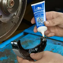 Nakładanie smaru ATE Plastilube na prowadnice hamulcowe. To właściwy smar do prowadnic hamulcowych, zapewniający płynne działanie.