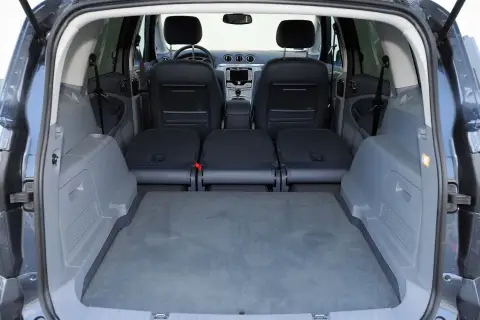 Wnętrze Ford S-Max z rozłożonymi siedzeniami. Widok od tyłu na bagażnik i fotele. Sprawdź ford s max wymiary, by zaplanować podróż.