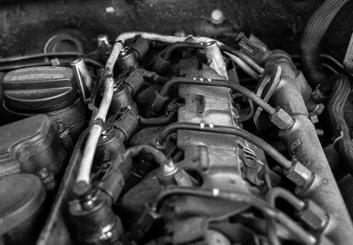 Widok silnika samochodowego, z widocznym korkiem wlewu oleju z napisem "To avoid damage to engine oil must not exceed max". Może to sugerować, że jest za dużo oleju w silniku.