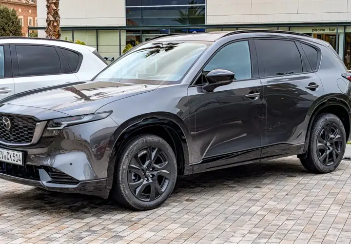 Ciemnoszara Mazda CX-5 na czarnych felgach, gotowa do jazdy. Wiele osób chwali ten model, a opinie o Mazda CX-5 są zazwyczaj pozytywne.
