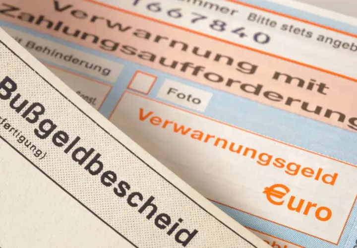 Zbliżenie na niemieckie mandaty, w tym "Bußgeldbescheid" i "Verwarnungsgeld" z symbolem euro.