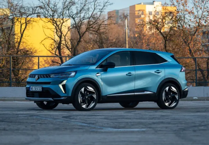 Niebieski Renault Symbioz na tle budynków i drzew. Wiele osób szuka o nim pozytywnych **renault symbioz opinie**.