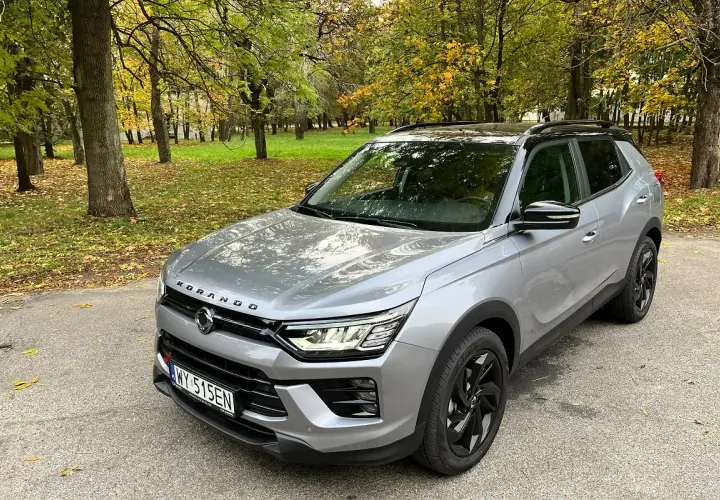 Srebrny SsangYong Korando na tle jesiennego parku. Wiele pozytywnych ssangyong korando - opinie użytkowników potwierdza jego wszechstronność.