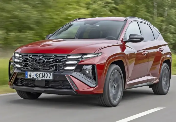 Czerwony Hyundai Tucson w ruchu drogowym. Zwróć uwagę na jego nowoczesny design i imponujące **hyundai tucson wymiary**, które zapewniają komfort i przestronność.
