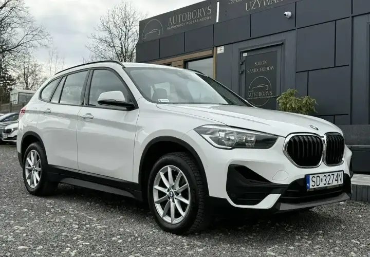 Białe BMW iX1 przed salonem samochodowym. Sprawdź atrakcyjną bmw ix1 cena!