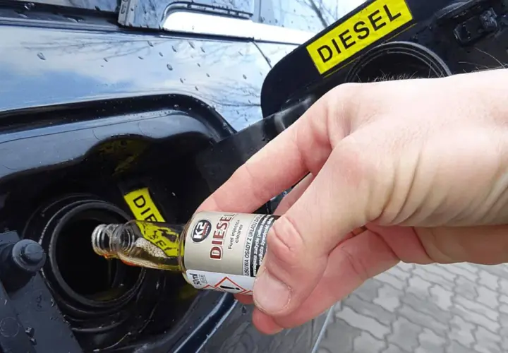 Ręka wlewa dodatek do paliwa benzyna do baku diesla.