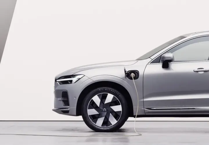 Srebrny samochód typu PHEV jest ładowany. To połączenie silnika spalinowego i elektrycznego, co oznacza, że możesz jeździć na prądzie lub paliwie.