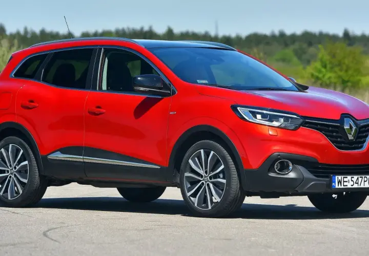 Czerwony Renault Kadjar na drodze. Wiele pozytywnych **renault kadjar opinie** potwierdza jego atrakcyjny wygląd i komfort jazdy.