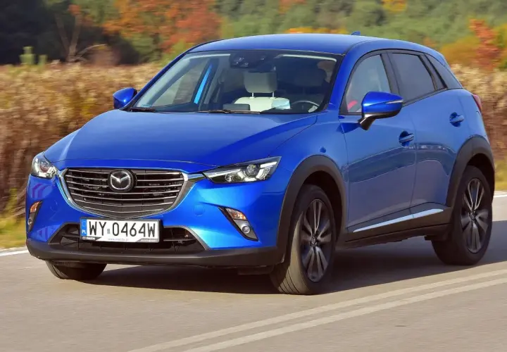 Niebieska Mazda CX-3 na drodze. Wiele pozytywnych mazda cx-3 opinie potwierdza jej stylowy wygląd i dynamikę jazdy.