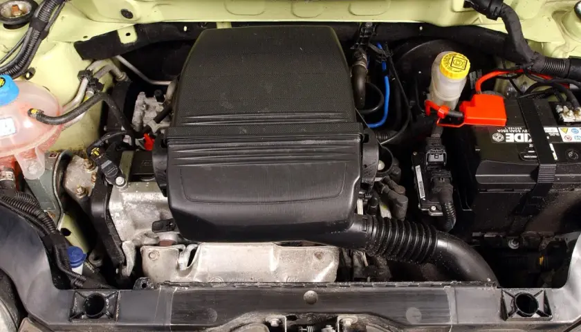 Silnik fiat panda 2, widok z góry. Widać akumulator, zbiorniczek płynu hamulcowego i osłonę silnika.