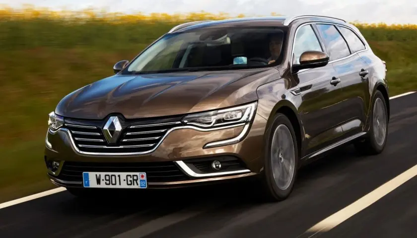 Brązowe kombi Renault Talisman na drodze. Wiele osób szuka renault talisman opinie przed zakupem.
