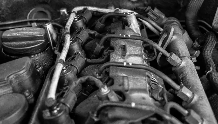 Widok silnika samochodowego, z widocznym korkiem wlewu oleju z napisem "To avoid damage to engine oil must not exceed max". Może to sugerować, że jest za dużo oleju w silniku.