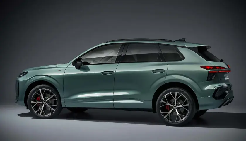 Zielony Audi Q3 z profilu, pokazujący jego sportowy design i eleganckie linie. Poznaj audi q3 wymiary i możliwości tego SUV-a.