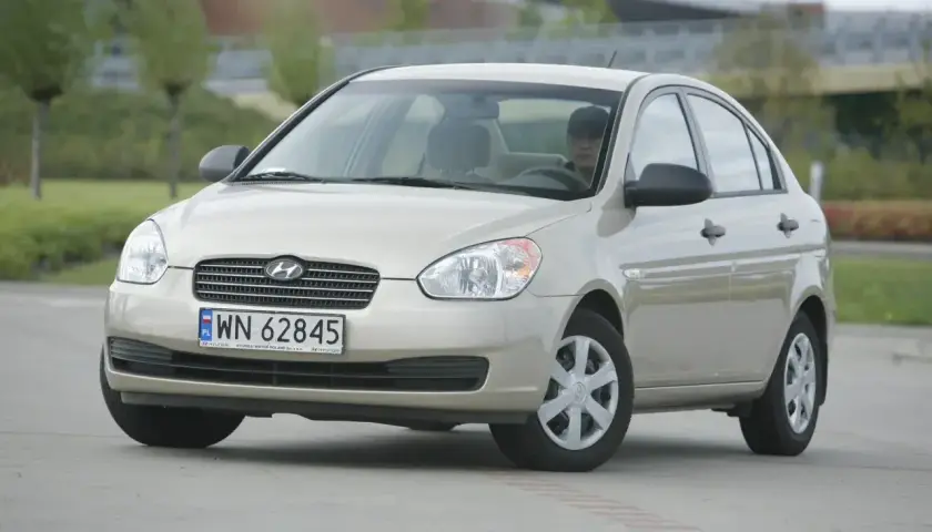 Złoty Hyundai Accent z polskimi tablicami WN 62845 zaparkowany na zewnątrz.
