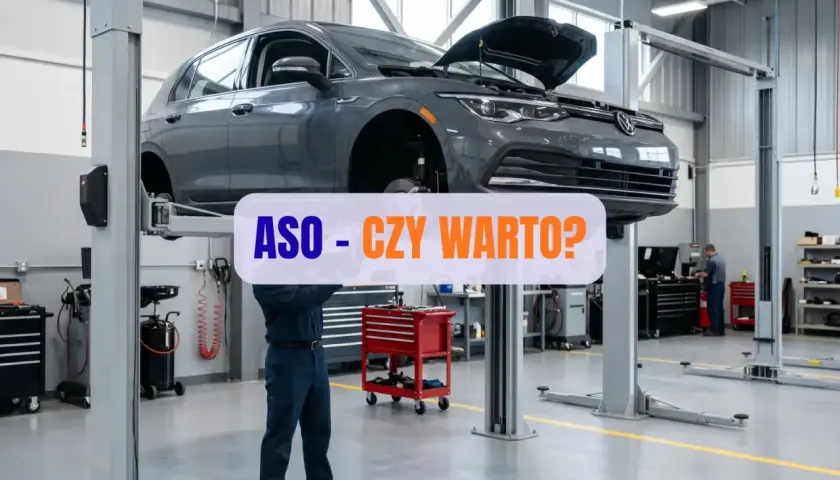 Mechanik pracuje pod samochodem na podnośniku w ASO. Czy warto?