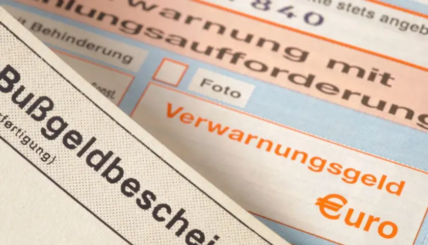 Zbliżenie na niemieckie mandaty, w tym "Bußgeldbescheid" i "Verwarnungsgeld" z symbolem euro.