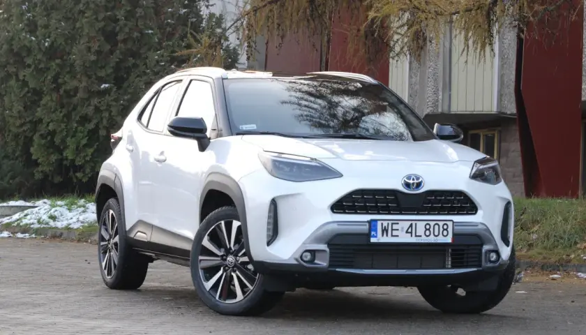 Biały Toyota Yaris Cross 2025 z czarnymi dodatkami, zaparkowany na zewnątrz.