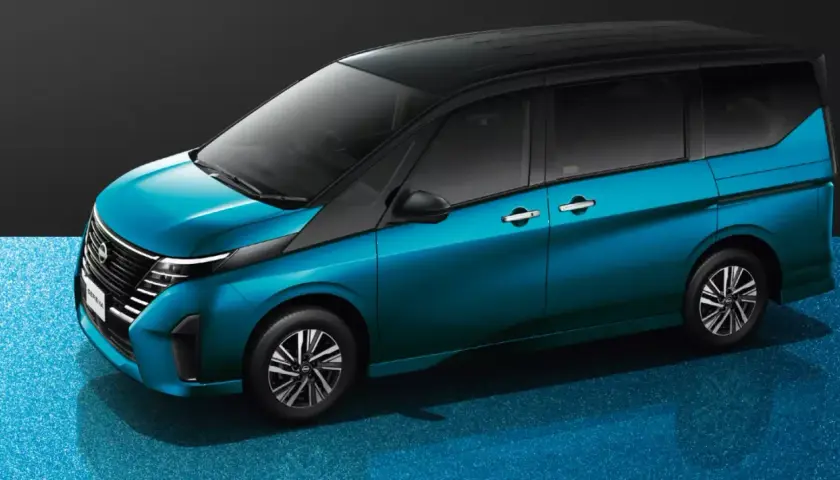 Elegancki, błękitny Nissan Serena z czarnym dachem prezentuje się nowocześnie na błyszczącym, niebieskim tle.