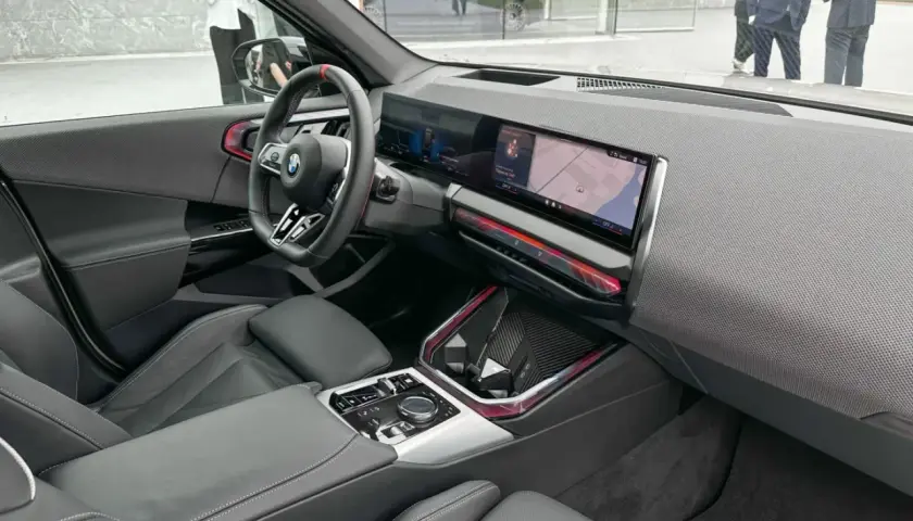 Wnętrze BMW X3 2025 z nowoczesnym ekranem multimedialnym i sportową kierownicą.