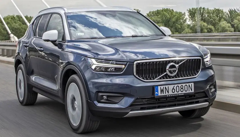 Ciemnoszary Volvo XC40 jedzie po moście. Sprawdź aktualną volvo xc40 cena i dostępne wersje.