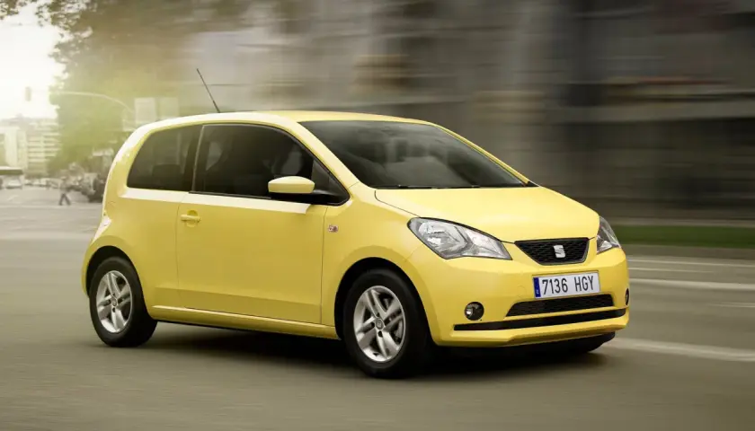 Żółty Seat Mii pędzi ulicą, tworząc wrażenie ruchu.