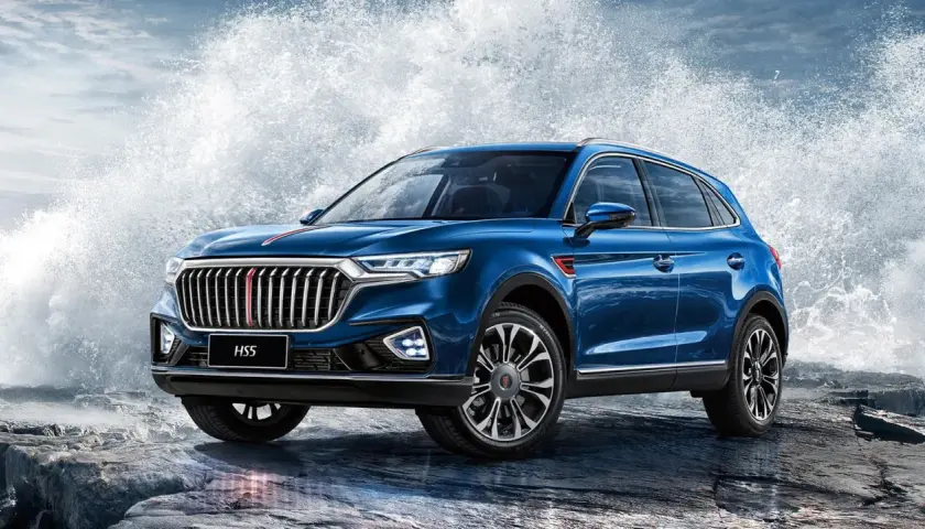 Niebieski Hongqi H5 na skalistym wybrzeżu, z potężnymi falami rozbijającymi się za nim.