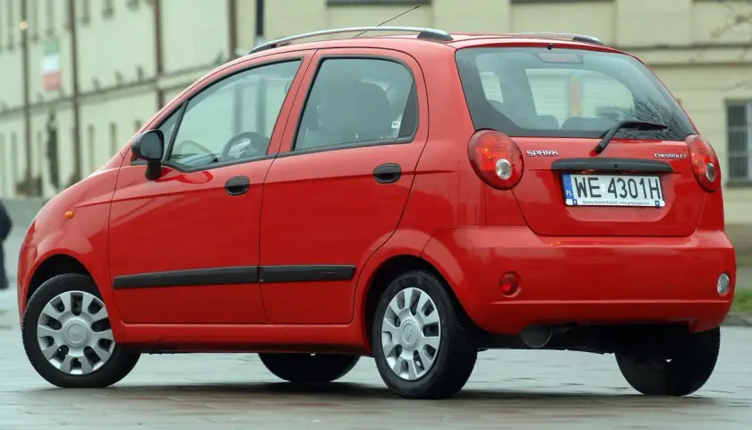Czerwony Chevrolet Matiz, model Spark, zaparkowany na ulicy.