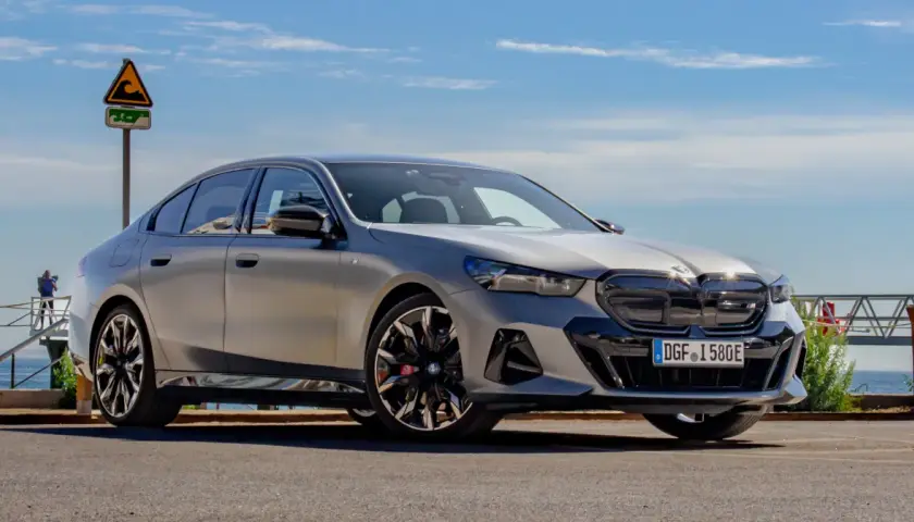 Srebrne BMW 520 z czarnymi akcentami stoi na tle błękitnego nieba i morza.
