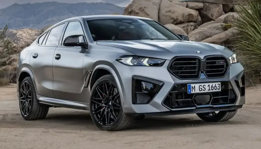 Srebrne x6 BMW z czarnymi felgami na tle skalistego krajobrazu.