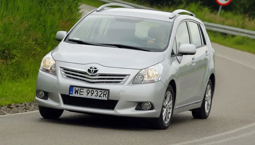 Srebrny Toyota Verso S jedzie po drodze, za kierownicą siedzi osoba.