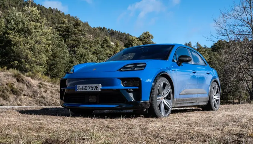 Niebieski Macan GTS na tle leśnego krajobrazu.