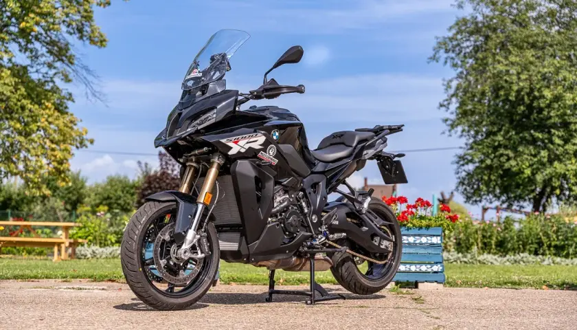 Czarny motocykl sportowo-turystyczny BMW 1000 XR na postoju, gotowy do podróży.