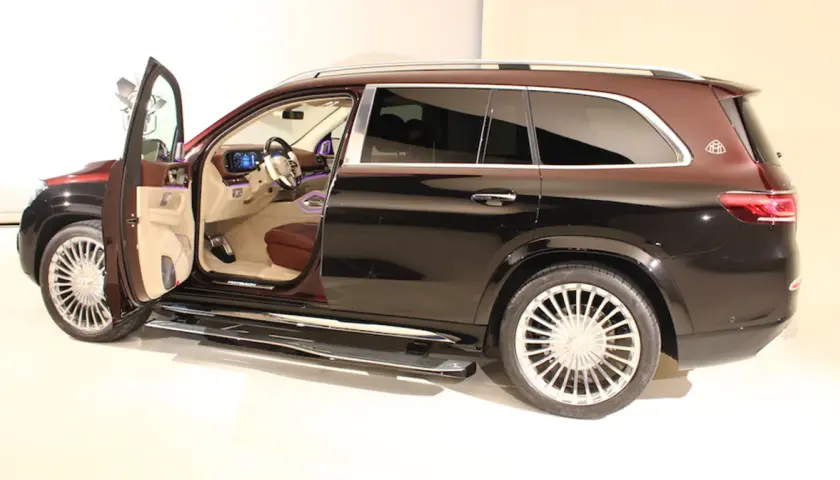 Mercedes-Maybach GLS z otwartymi drzwiami, widoczne luksusowe wnętrze i dwukolorowe nadwozie.